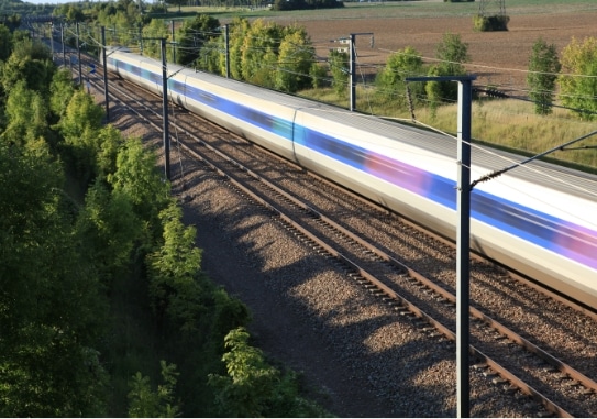 Plan large sur un TGV en mouvement en pleine campagne